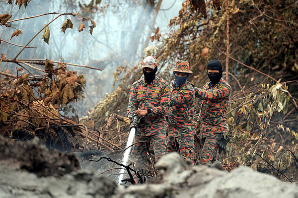 JBPM personnel actively fight a forest fire at Jalan Tanjung Kupang, Kampung Pekajang near Gelang Patah, today. — Bernama