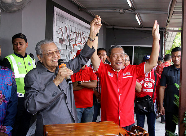 Prime Minister and leader of the Pakatan Harapan allience Tun Dr Mahathir (right) lifts the hand of Tanjung Piai parliamentary candidate Karmaine Sardini (right) as a symbol of support during a breakfast session here in Tanjung Piai today — Bernama