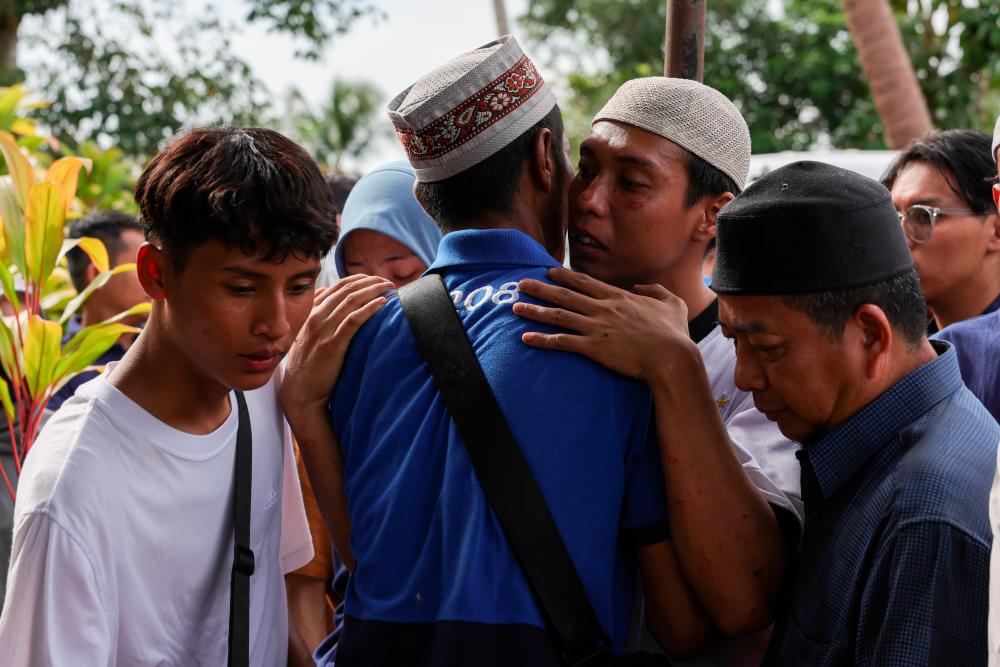 KOTA TINGGI, 16 Okt -- Redzuan Jamil (dua, kanan), 28, menerima ucapan takziah daripada saudara terdekat selepas selesai upacara pengkebumian isterinya, Nurul Nazihah Kamalul Arifin yang maut dalam kemalangan di KM45.7 PLUS arah selatan dekat Sedenak, semalam, yang selamat dikebumikan di Tanah Perkuburan Islam Kampung Temenin Lama, hari ini.--fotoBERNAMA