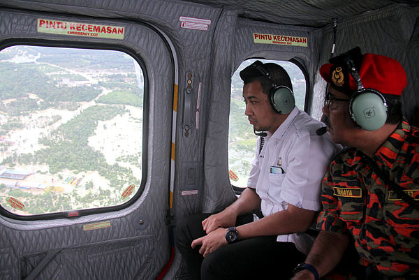 Johor Chief Minister Datuk Dr Sahruddin Jamal (left) and Director of Johor Fire and Rescue Department Datuk Yahaya Madis observes the flood situation in Johor by helicopted on Dec 16 — Bernama