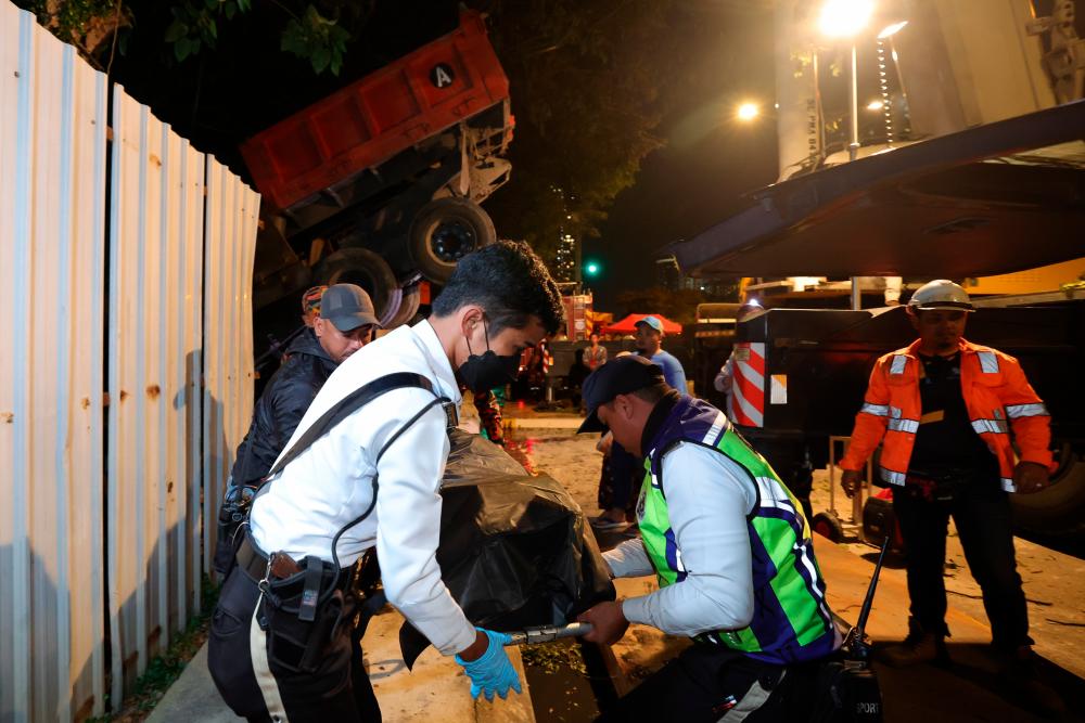 JOHOR BAHRU, Dec 24 -- Members of the Malaysian Fire and Rescue Department and the Royal Malaysian Police brought out the body of a lorry driver who was trapped after crashing into a wall and plunging into a ditch at the Jalan Sultan Ibrahim traffic light junction yesterday. BERNAMAPIX