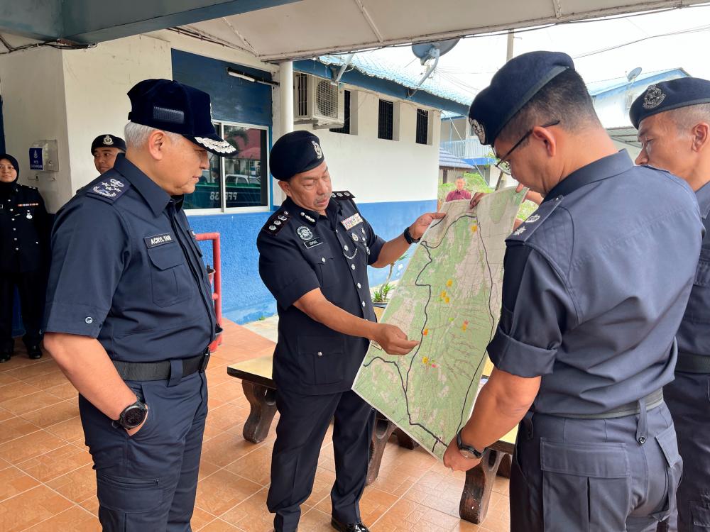 BATU PAHAT, Jan 29 -- Inspector-General of Police Tan Sri Acryl Sani Abdullah Sani (left) looks at a map of the flood area in Batu Pahat district involving Sri Medan and Yong Peng areas. BERNAMAPIX
