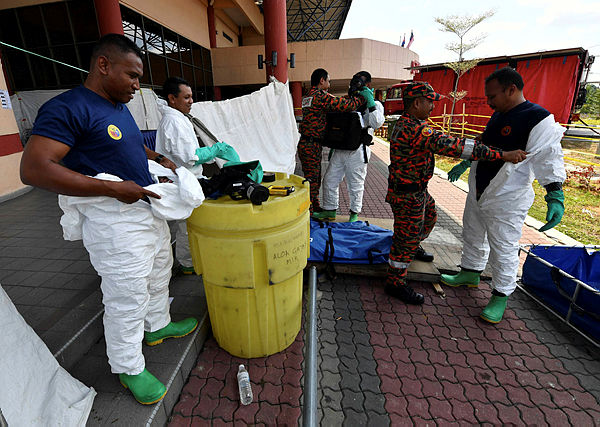 A Hazmat team removes their equipment after clean up duty in Pasir Gudang, on March 20. — Bernama