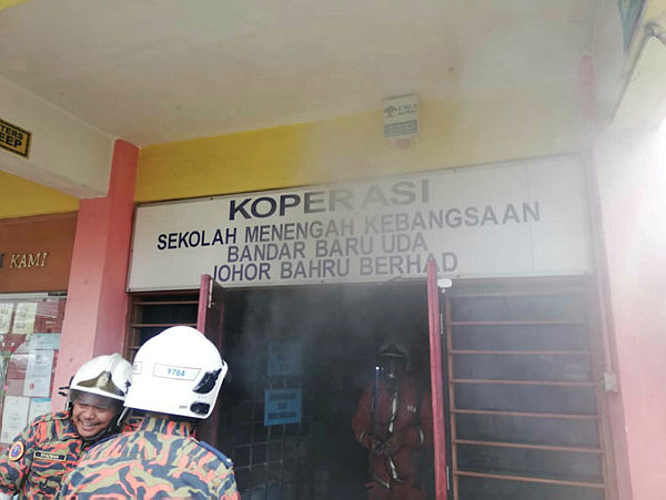Firemen seen at the fire incident in the cooperative room of Sekolah Menengah Kebangsaan (SMK) Bandar Baru Uda, here today. — Bernama