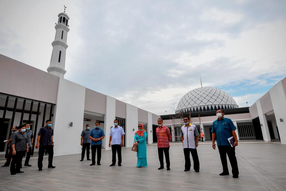 Prime Minister Tan Sri Muhyiddin Yassin (3rd from R) and Puan Sri Noorainee Abdul Rahman (4th from R) share memories during a visit to the construction site of the Haji Muhammad Yassin Mosque in the Pagoh Higher Education Hub in Bandar Universiti Pagoh today. - Bernama
