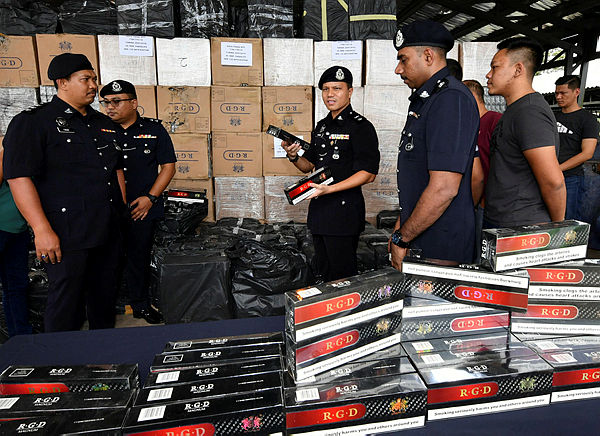 Kota Tinggi police chief Supt Ahsmon Bajah (C) with other police personnel display some of the 362 boxes, each containing 50 cartons of white cigarettes under the ‘RGD Magnum’ label worth RM710,000 at a press conference. — Bernama