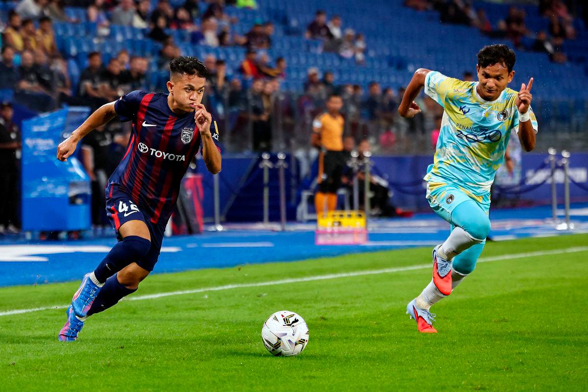 Pemain JDT, Arif Aiman Mohd Hanapi (kiri) melepasi kawalan pemain Penang FC Ahmad Irfan Mohd Noor (kanan) pada perlawanan Liga Super Malaysia 25/26 di Stadium Sultan Ibrahim hari ini. Keputusan, JDT 6 - 0 Penang FC - fotoBERNAMA