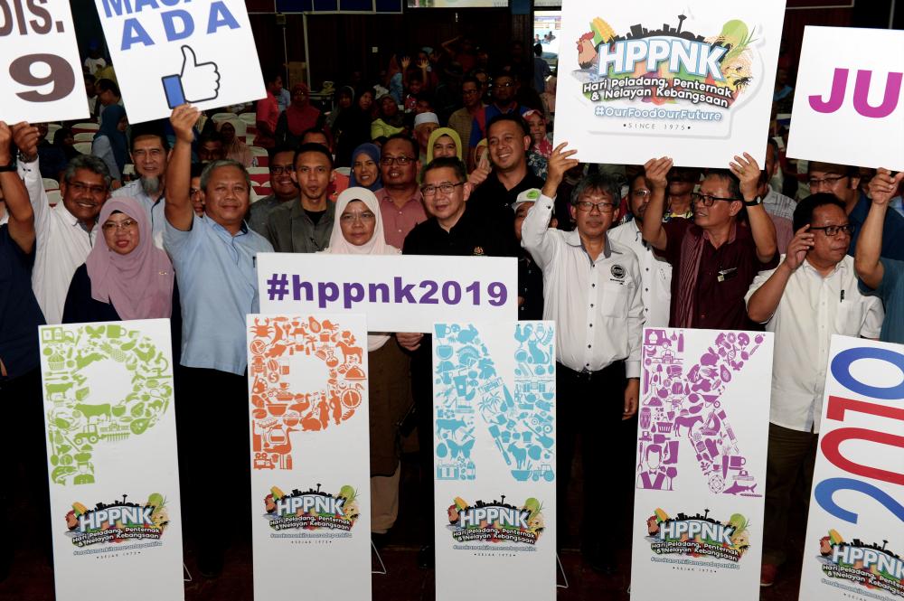 Agriculture and Agro-based Industry Minister Datuk Seri Salahuddin Ayub (C) and representatives from Malaysian Agricultural Research and Development Institute (Mardi) with Pekan Nenas community on Mardi Day, Oct 13, 2019. — Bernama