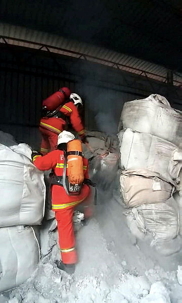 Firemen putting out the fire that engulfed 24 bags containing aluminium dross chemical waste at Jalan Perindustrian 5, Pontian Industrial Area, — Bernama