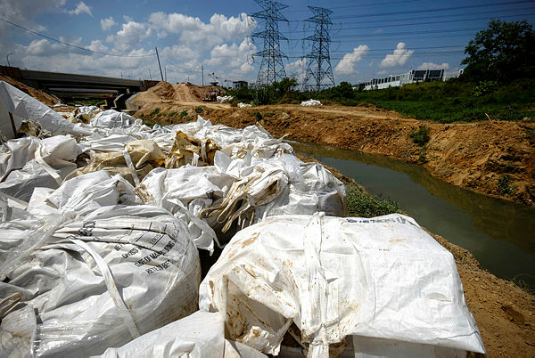Bags containing contaminated soil are collected before being transported to the disposal center in the pollution incident area at Sungai Kim Kim, near Pasir Gudang on March 16, 2019. — Bernama
