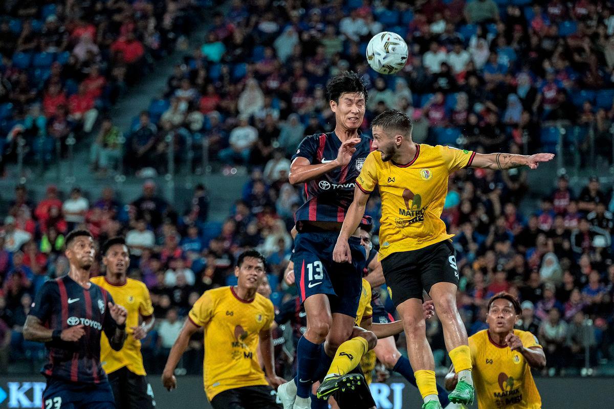 Pemain JDT Park Juenhong (dua, kanan) melepaskan tandukan sambil dihalang pemain Negeri Sembilan FC Jovan Motika (kanan) pada saingan Liga Super Malaysia 2025/2026 di Stadium Sultan Ibrahim hari ini. - fotoBERNAMA