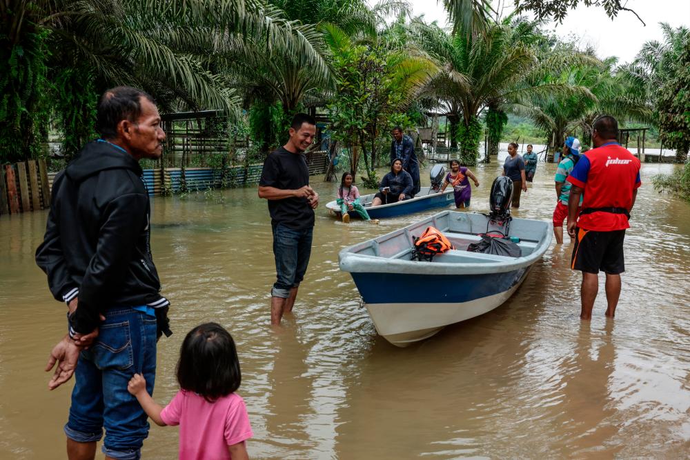 MERSING, 29 Jan -- Penduduk Kampung Jamari meredah banjir selepas kampung mereka dinaiki air semula ekoran hujan berterusan sejak malam semalam. fotoBERNAMA