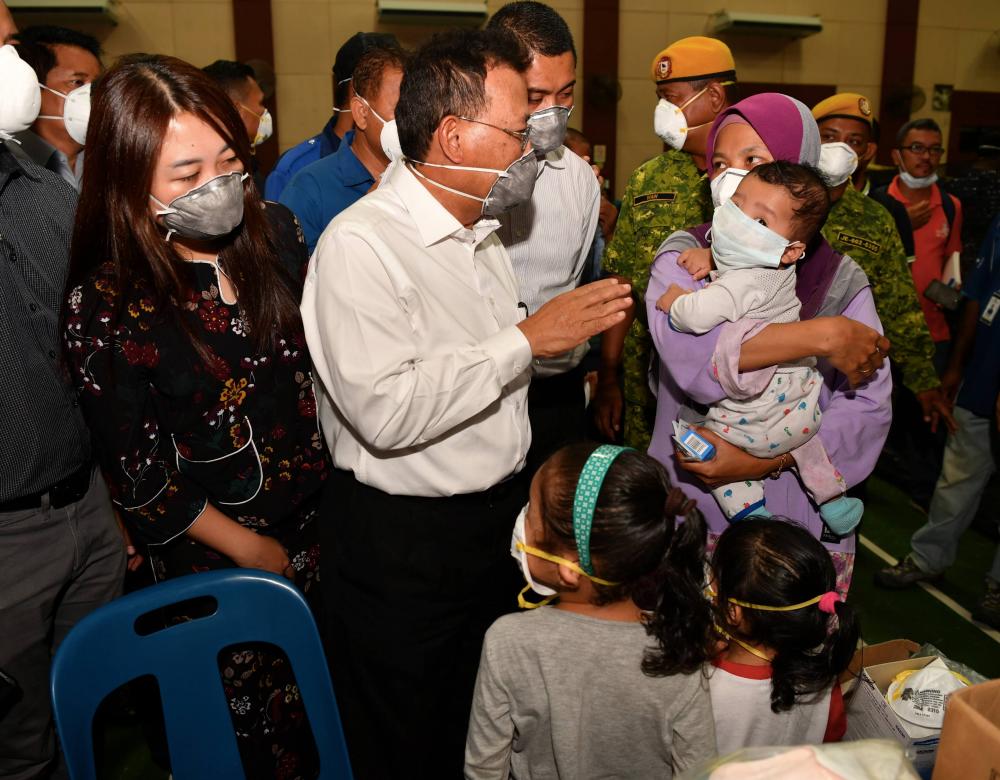 Johor Mentri Besar Datuk Osman Sapian speaks to a mother who is getting a treatment while visiting a chemical waste contaminant, at the Taman Pasir Putih Community Hall in Pasir Gudang, on March 14, 2019. — Bernama