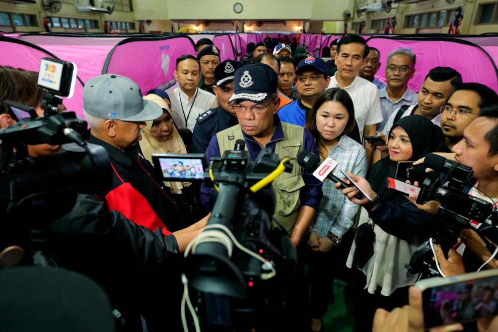 KLUANG, 3 Mac -- Menteri Dalam Negeri Datuk Seri Saifuddin Nasution Ismail (tengah) ketika ditemui pengamal media pada lawatan di Pusat Pemindahan Sementara (PPS) Dewan Orang Ramai Kampung Melayu hari ini. fotoBERNAMA