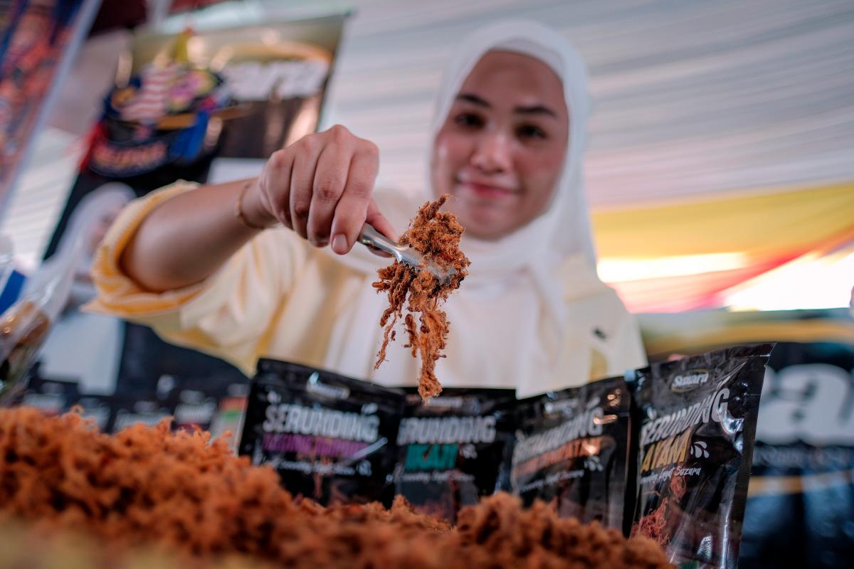 Usahawan dodol Nur Atikah Syazwani Hassan, 30, menunjukkan produk serunding yang turut dijual selain dodol telur dan dodol gelembung buaya pada Karnival Kita MADANI yang diadakan bersempena dengan Majlis Peluncuran Bulan Kebangsaan dan Kibar Jalur Gemilang 2025 di Dataran Tanjung Emas di sini hari ini - BERNAMA