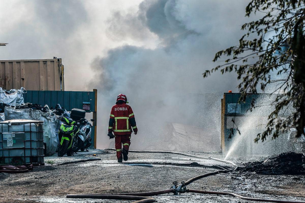 Anggota Bomba dan Penyelamat memasuki kawasan kebakaran di Kawasan Perindustrian Kota Puteri berhampiran Taman Megah Ria hari ini. BERNAMA