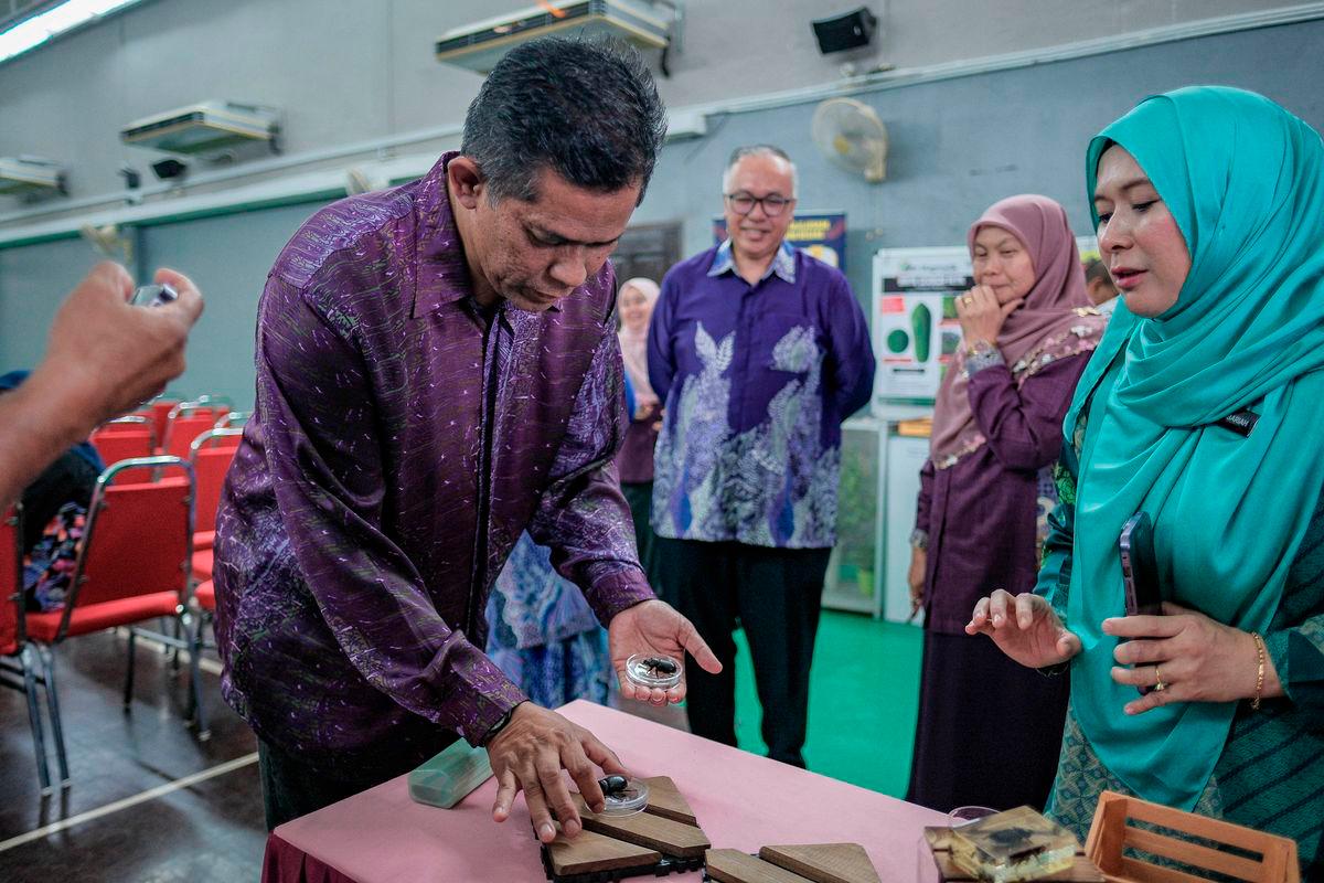 Timbalan Ketua Pengarah Pertanian (Pengurusan dan Regulator) Mat Iesak Ngathinee (kiri) melihat kumbang tanduk pada Majlis Perasmian Penutup Seminar Ancaman Spesies Asing Invasif terhadap Tanaman Kelapa dan Kelapa Sawit di Pusat Pertanian Ayer Hitam, hari ini. - BERNAMA