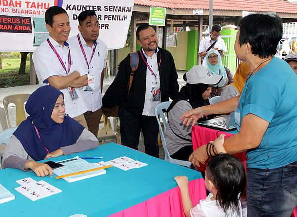 Election Commission Chairman Datuk Azhar Harun (standing, left) engages with voters while he supervises the Tanjung Piai by-election in SMK Dato’ Mohd Yunos Sulaiman, Pekan Nanas today — Bernama
