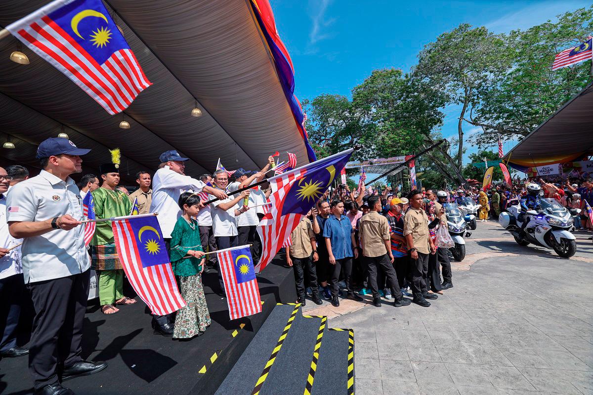 Prime Minister Datuk Seri Anwar Ibrahim flagging off participants during the departure of the Jalur Gemilang flag-flying convoy after the National Month 2025 Launching Ceremony at Dataran Tanjung Emas today. - Bernama pic