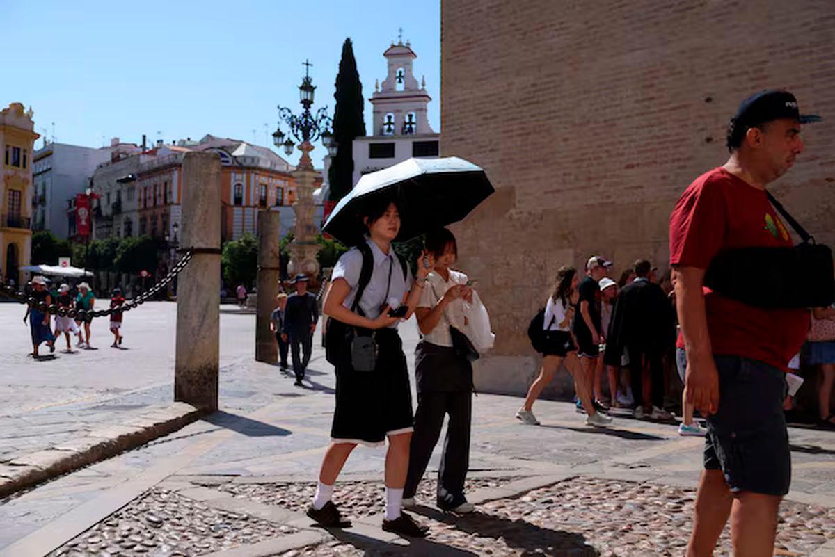 People walk during a heatwave, in Seville, Spain, July 2, 2025. REUTERS/Claudia Greco