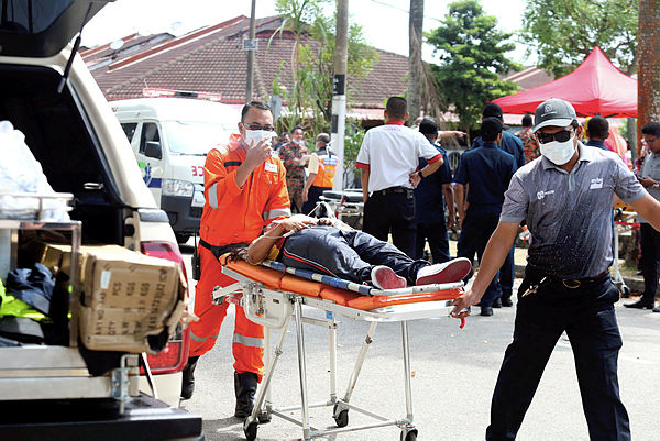 A medical team transports students to the hospital after they fell ill from chemical wastes at Sungai Kim Kim near Taman Pasir Putih, Pasir Gudang. — BBXpress