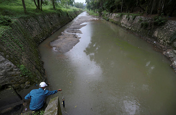 FIlepix taken on June 26 shows a member of the Department of Environment (JAS) performing a check on the water quality at Sungai Kim Kim, Pasir Gudang