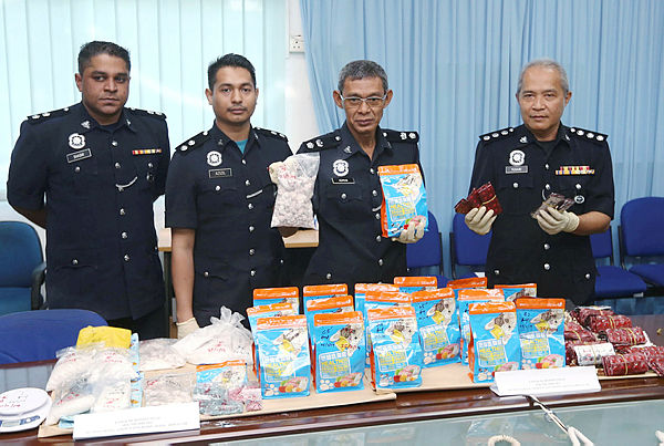 Tangkak district police chief Supt Mohad Idris Samsuri (2nd from R) displays a 13.323kg drugs seizure worth RM280,212 from a raid in Taman Sialang Park at Tangkak district police headquarters. — BBXpress