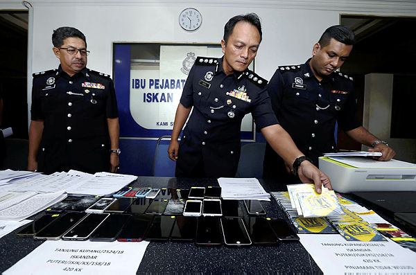 Iskandar Puteri district police chief, ACP Dzulkhairi Mukhtar (C) shows items seized from a loan scam syndicate during a media conference at IPD Iskandar Puteri on Jan 31, 2019. — BBXpress