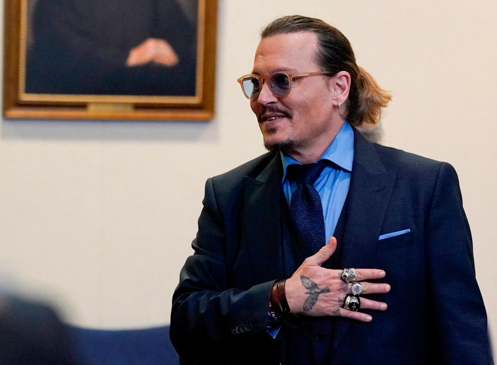 Actor Johnny Depp gestures to spectators in court after closing arguments during his defamation case against ex-wife Amber Heard at the Fairfax County Circuit Courthouse in Fairfax, Virginia, U.S., May 27, 2022. Steve Helber/Pool via REUTERSpix