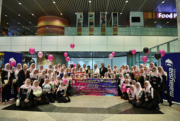 Sekolah Seri Puteri Symphonic Winds Orchestra with Malaysia Airlines’ Group Chief Corporate Services Officer, Nik Azli Abu Zahar (2nd row, in white) and Tuan Hasnal Hashim, chairman of the Parent-Teacher Association of Sekolah Seri Puteri (2nd row, in black), upon arrival at KLIA from Sydney.