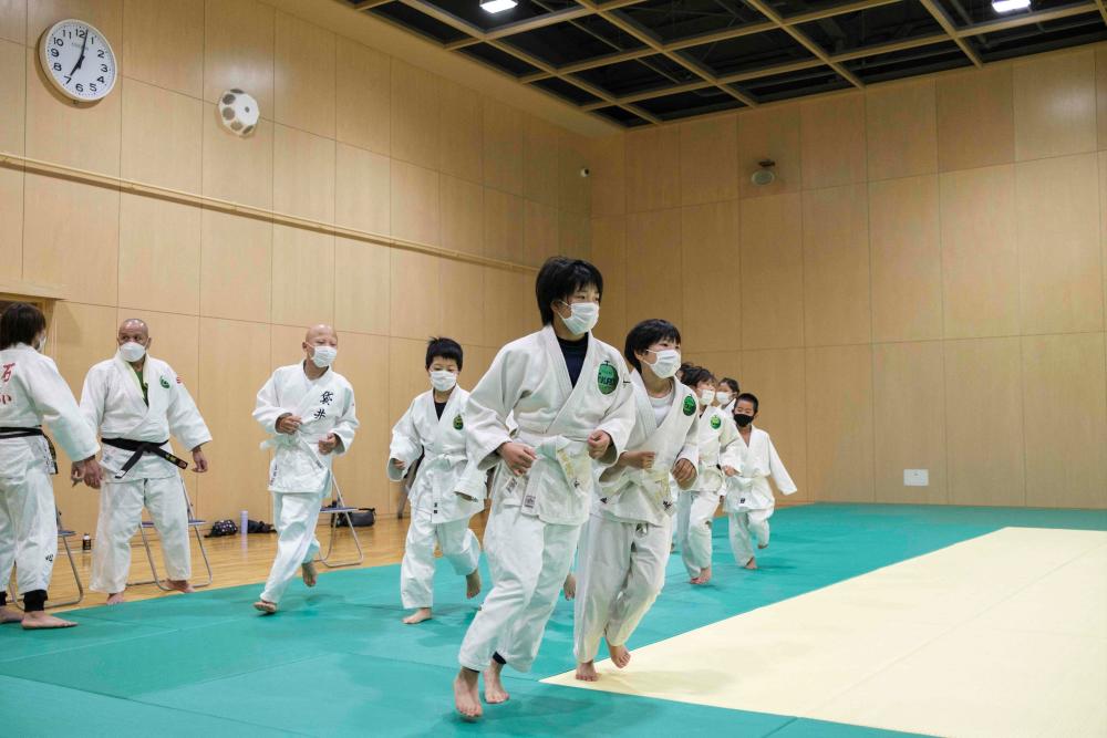 This photo taken on May 25, 2022 shows children warming up for a judo training session in Fukuroi, Shizuoka prefecture. Japan is the home of judo but a brutal win-at-all-costs mentality, corporal punishment and pressure to lose weight is driving large numbers of children to quit the sport. AFPPIX