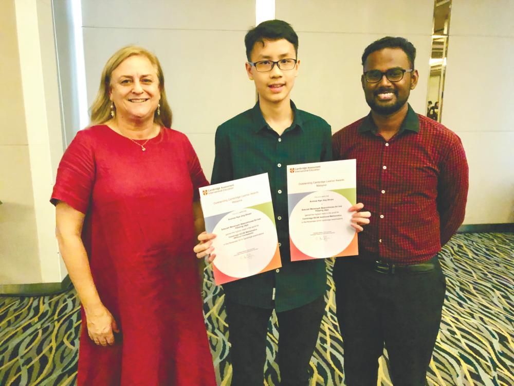 All smiles at the awards presentation are (from left) Beaconhouse Sri Inai International School executive principal Nicki Coombs, Andrew and his Add Math teacher (Beaconhouse) Devarajen Sinanah.
