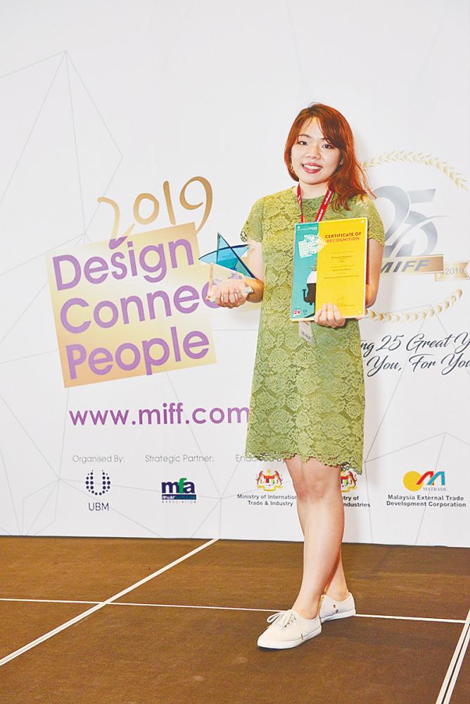 Noviaputri with her trophy and certificate at the MIFF FDC 2019.