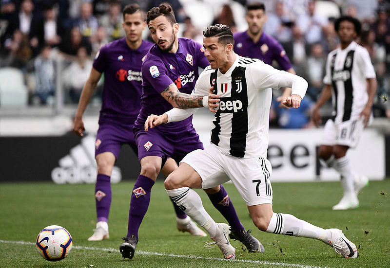 Fiorentina Federico Ceccherini (L) holds off Juventus’ Cristiano Ronaldo during their Serie A match on April 20, 2019 at the Juventus stadium in Turin. — AFP