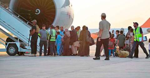 Passengers prepare to board a Qatar Airways aircraft at the airport in Kabul. -AFPPix