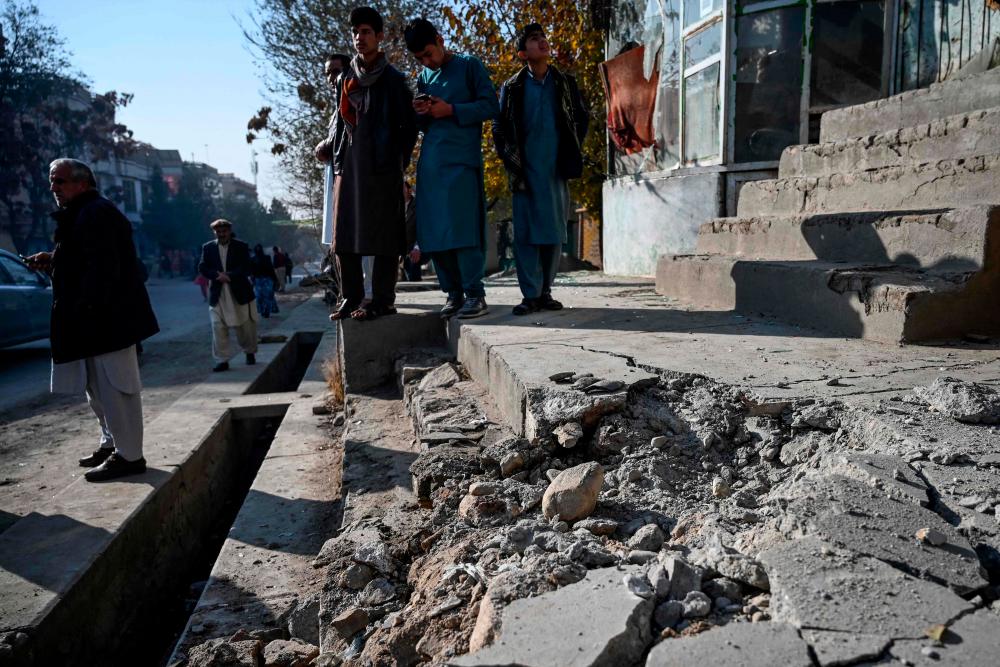 Residents gather at a site after several rockets land at Khair Khana, north west of Kabul on November 21, 2020. — AFP