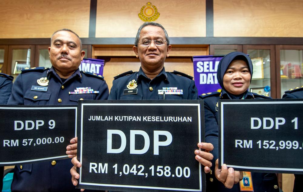 Kelantant Road Transport Department deputy director Nik Azhan Ab Hadi, and colleagues display the the DDP number plates which fetch the highest amounts, on Sept 8, 2019. — Bernama