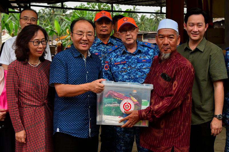 Duta Besar China Ke Malaysia Ouyang Yujing (dua, kiri) melakukan gimik penyerahan pek makanan kepada Penghulu Mukim Kampung Pulau Gorek Che Kob Che Abdullah (dua, kanan) pada program Bantuan Mangsa Banjir di Masjid Mukim Pulau Gorek hari ini. - fotoBERNAMA