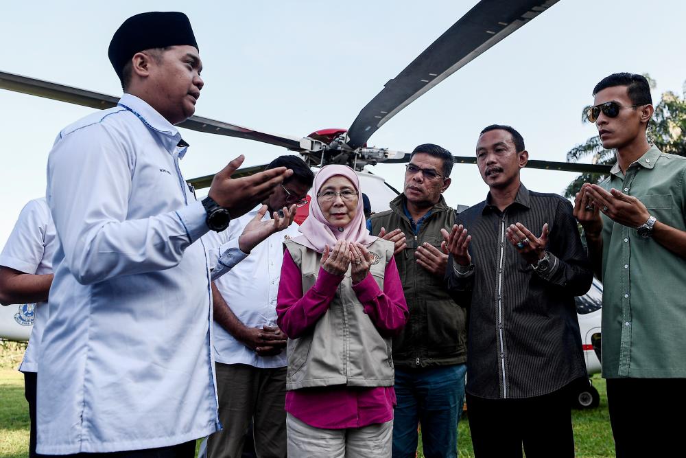 Deputy Prime Minister Datuk Seri Dr Wan Azizah Wan Ismail (C) performs a prayer upon arrival at Felda Aring 10 on June 14. 2019. — Bernama