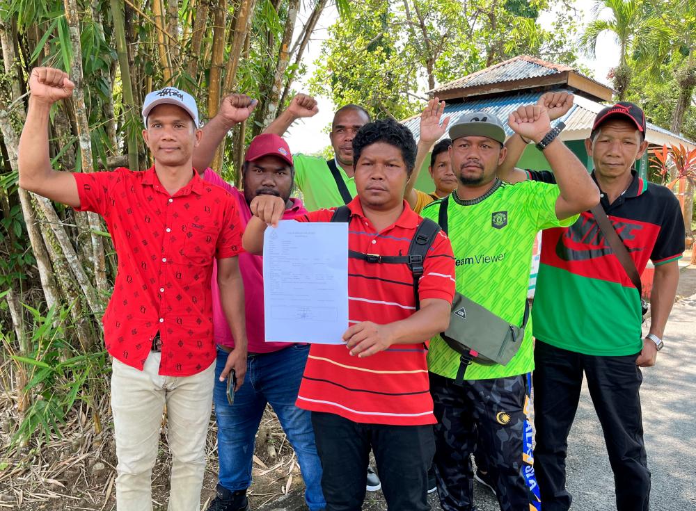 GUA MUSANG , July 25 -- An indigenous resident of the Temiar tribe from Kampung Jelgek B, Ramli Ajom, 34, (third, right) shows the police report made at the Gua Musang District Police Headquarters (IPD) when met by reporters in Bandar Baru, today. BERNAMAPIX