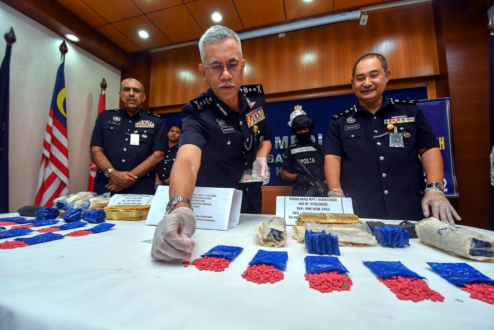 Kelantan police chief Datuk Hasanuddin Hassan (C) and other officers display some of the 18,000 ‘pil kuda’ worth RM180,000 which were seized in Pasir Mas, at a press conference at the Kelantan police contingent headquarters today. - Bernama