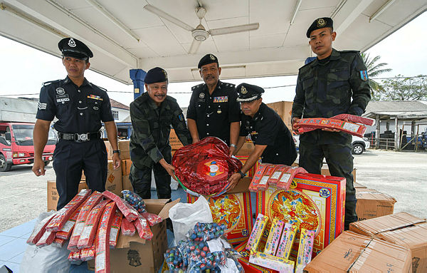 Pasir Mas deputy police chief Supt Ismail Jusoh (C) with 7th Battalion commanding officer, Kuantan PGA DSP Ab Aziz Che Embong (2nd from L), among others, pose with fireworks worth RM30,000 which was seized in a raid in Rantau Panjang last Saturday, during a media conference at Pasir Mas Police Headquarters (IPD) on Jan 31, 2018. — Bernama