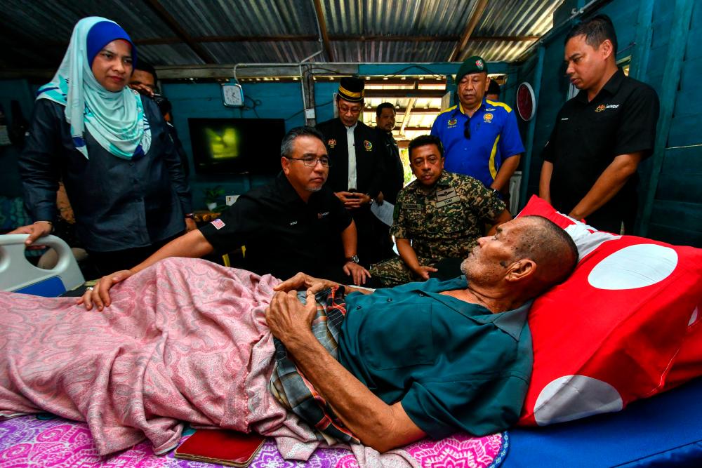 KOTA BHARU, 18 Mac -- Timbalan Menteri Pertahanan, Adly Zahari (dua, kiri) melawat veteran Angkatan Tentera Malaysia (ATM), Lans Koperal Che Ahmad Mamat, 66, yang terlantar akibat menghidap komplikasi usus pada Jelajah Program Peduli Veteran ATM (PPV) di Kampung Pulau Panjang, Pengkalan Chepa hari ini. fotoBERNAMA
