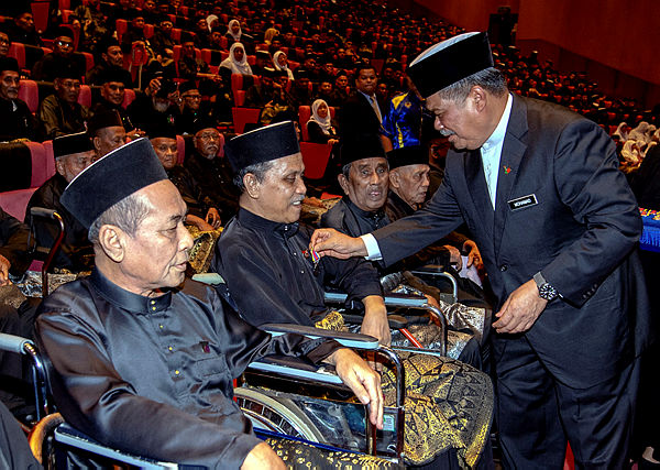 Defense Minister Mohamad Sabu (R) presents the Malaysian Service Medal to armed forces veteran Wan Salri Wan Daud, 61, at the Kelantan and Terengganu Award Ceremony. — Bernama