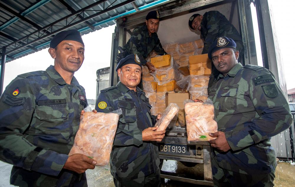 PGA7 commanding officer Supt Azhari Nusi (2nd from L) and his staff display the frozen chickens, among some RM100,000 worth of seized goods during ‘Op Wawasan’ at the Malaysia-Thailand border. - Bernama