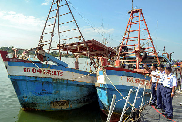Acting Kelantan MMEA director Ismail Hamzah (R) shows off the two foreign fishing boats that were seized with 21 Vietnamese crew members at Tok Bali. — Bernama