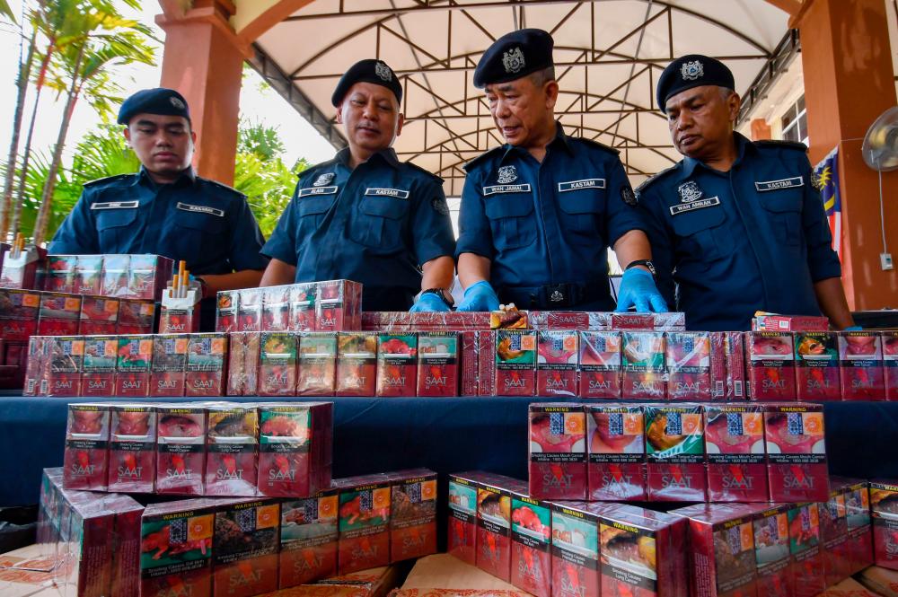 PASIR MAS, 25 April -- Pengarah Jabatan Kastam Diraja Malaysia (JKDM) Kelantan Wan Jamal Abdul Salam Wan Long (dua, kanan) menunjukkan sebahagian rampasan rokok seludup pada sidang media di Pejabat Penguatkuasaan JKDM Rantau Panjang hari ini. fotoBERNAMA