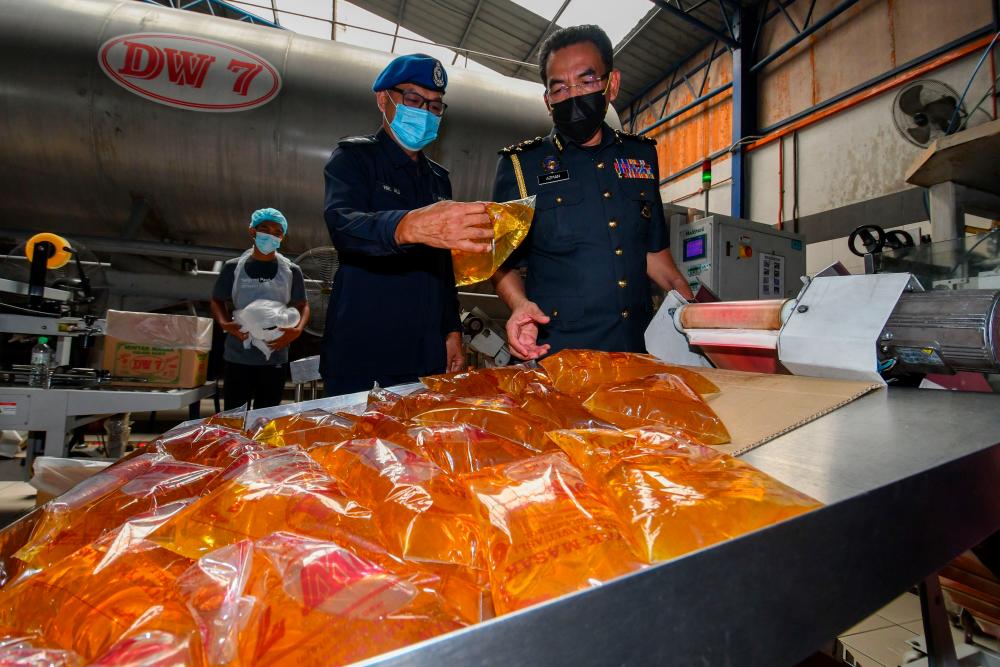 BACHOK, July 5 - Ministry of Trade and Consumer Affairs (KPDNHEP) Enforcement Director Azman Adam (right) during an inspection of cooking oil supply at a cooking oil packaging plant in Tanjung Pauh Trading &amp; Construction Gelang Buluh Industrial Area, Beris Kubor today. BERNAMAPIX