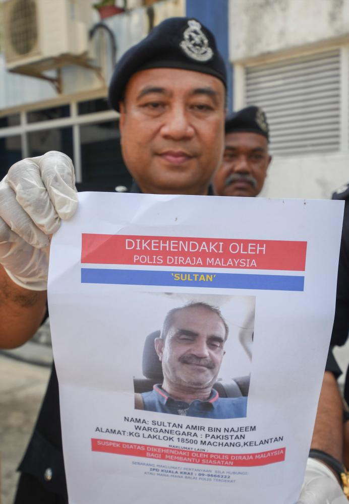 Kuala Krai District Police acting chief DSP Wan Fauzi Wan Ishak showing a photo of the suspect. — Bernama