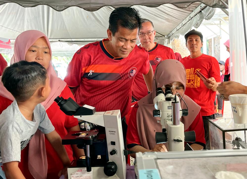 Pengarah Jabatan Kesihatan Negeri Kelantan (JKNK) Datuk Dr Zaini Hussin (tengah) meninjau aktiviti peserta di khemah kenali jenis nyamuk pembawa penyakit pada program Sambutan Hari Malaria Sedunia Peringkat Negeri Kelantan tahun 2023, di Ladang Rancangan Pemulihan Tanah (RPT) Kesedar Sungai Terah/BERNAMApix